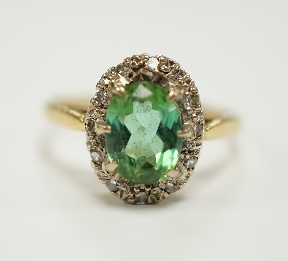 A modern 18ct gold, green tourmaline and diamond set oval cluster ring, size O/P, gross weight 3.5 grams.